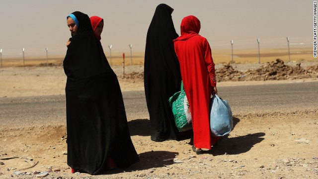 A group of women wait outside the temporary displacement camp in Khazair on June 26.