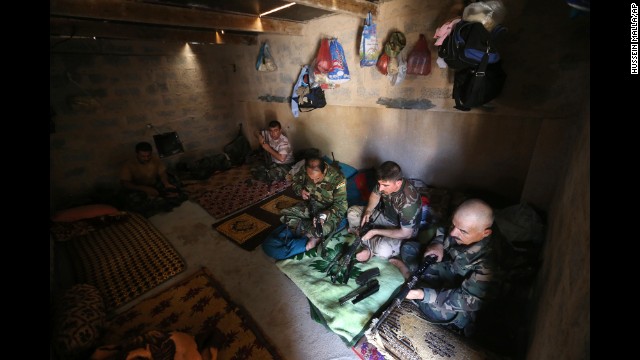 Peshmerga fighters clean their weapons at a base in Tuz Khormato, Iraq, on June 25.