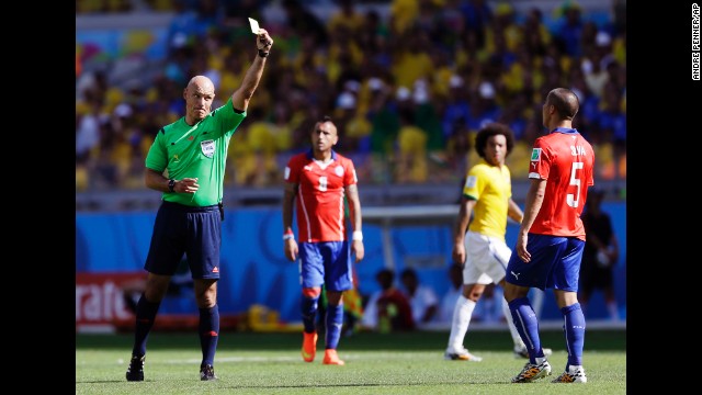 Referee Howard Webb gives a yellow card to Chile's Francisco Silva.