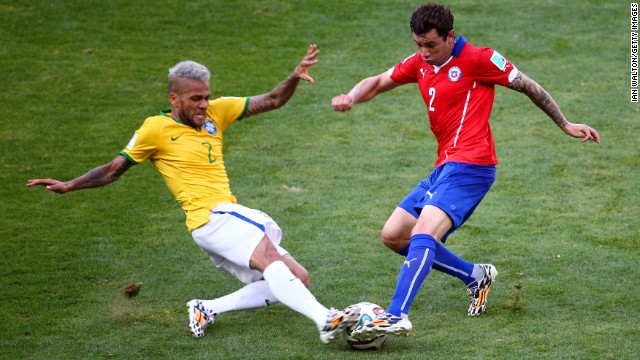 Dani Alves of Brazil and Eugenio Mena of Chile compete for the ball before the game went into penalty shootout.