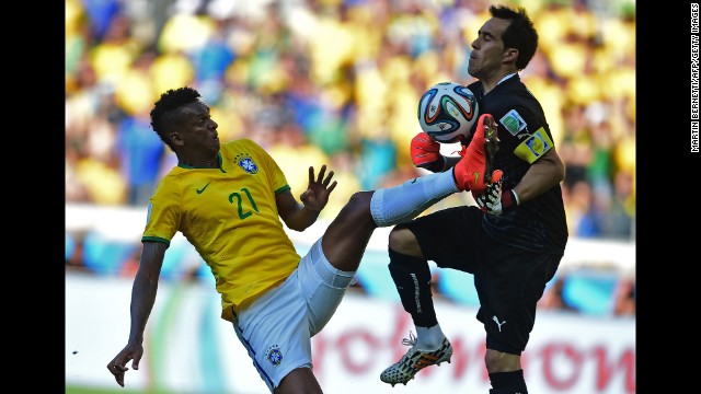 Jo of Brazil tries to score a goal as Chile's goalkeeper Claudio Bravo saves the ball.
