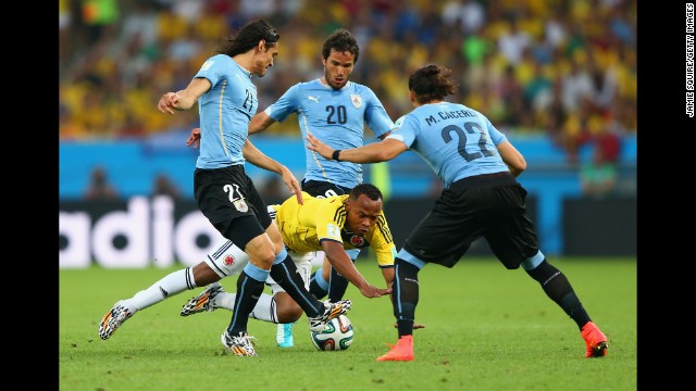 Juan Camilo Zuniga of Colombia is challenged by a trio of players from Uruguay.