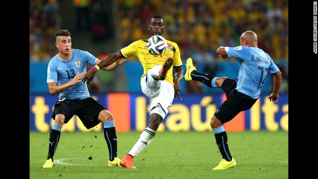 Jackson Martinez of Colombia controls the ball against Jose Gimenez, left, and Egidio Arevalo Rios of Uruguay.