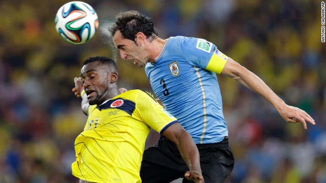 Colombia's Jackson Martinez and Uruguay's Diego Godin jump for the ball.
