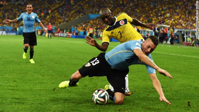 Jose Gimenez, in blue, of Uruguay is challenged by Pablo Armero of Colombia.
