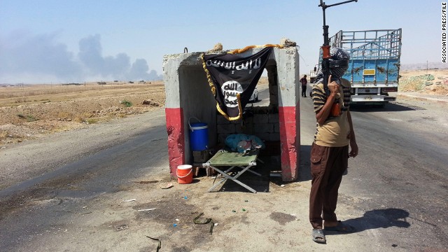 An ISIS militant stands guard at a checkpoint captured from the Iraqi Army outside Beiji refinery on June 19, 2014.