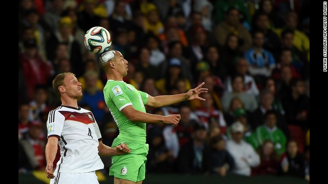 German defender Benedikt Hoewedes, left, competes for the ball with Algeria's Sofiane Feghouli.