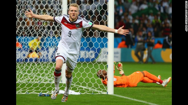 Andre Schuerrle of Germany celebrates scoring his team's first goal past goalkeeper M'Bolhi of Algeria.