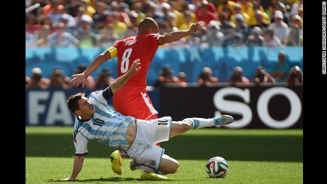 Messi and Swiss midfielder Goekhan Inler fight for the ball.