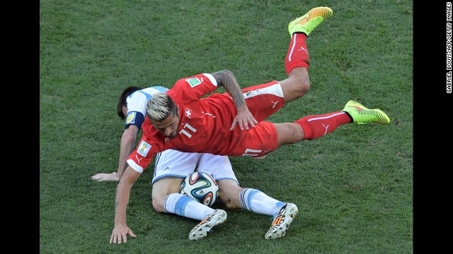 Swiss midfielder Valon Behrami falls on Messi.
