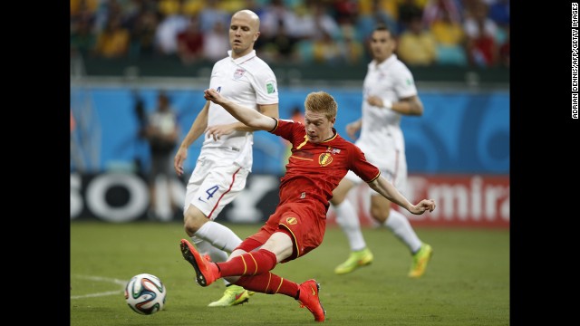 Bradley, left, looks on as De Bruyne kicks the ball.