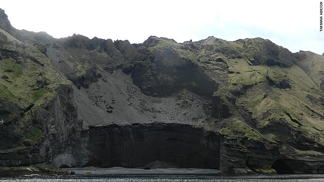 On boat rides around the Iceland's Heimaey Island, visitors pass towering banks of ash sloping down to the sea. 