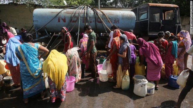 Residents fill up their baskets with water from a tanker April 24 in New Delhi.