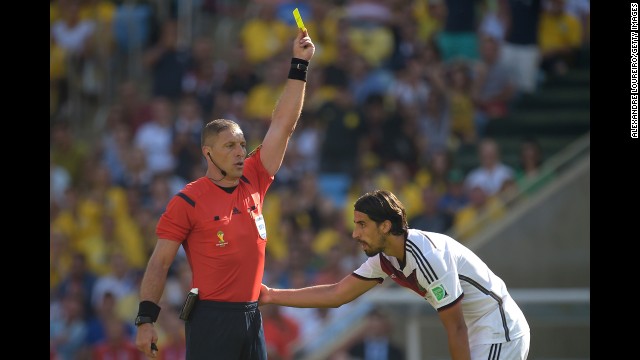Referee Nestor Pitana shows a yellow card to Germany's Sami Khedira.