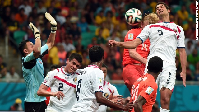 Netherlands forward Dirk Kuyt, second right, heads the ball marked by Costa Rica's midfielder Celso Borges. 