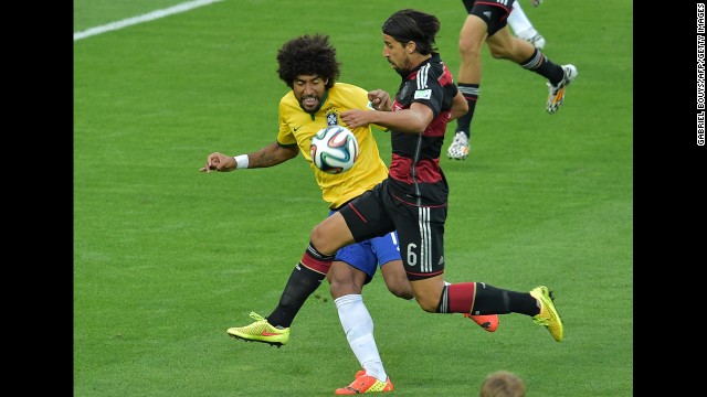 Brazilian defender Dante, left, fights off Germany's Sami Khedira.