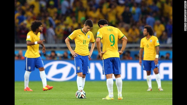 Brazilian players Oscar and Fred hang their heads after a German goal.