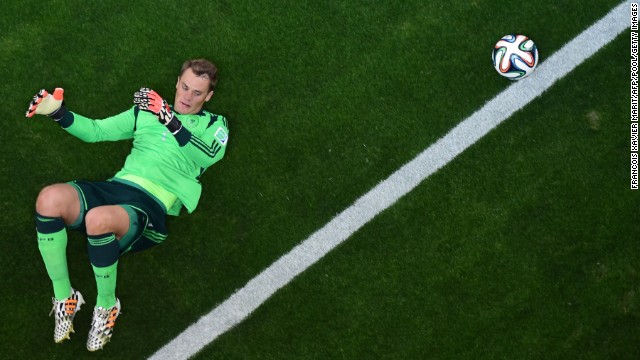 Neuer lies on the grass in the penalty box.