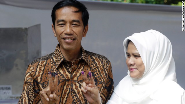 Indonesian presidential candidate Joko Widodo, at left, and his wife Iriana, show their inked fingers after casting their ballots during the presidential election in Jakarta on July 9.