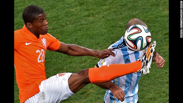 Georginio Wijnaldum of the Netherlands kicks the ball near Mascherano.