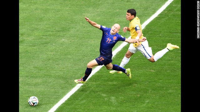 Brazil defender and captain Thiago Silva, right, fouls Netherlands forward Arjen Robben.