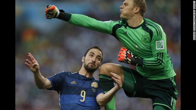 Neuer punches the ball before colliding with Higuain.