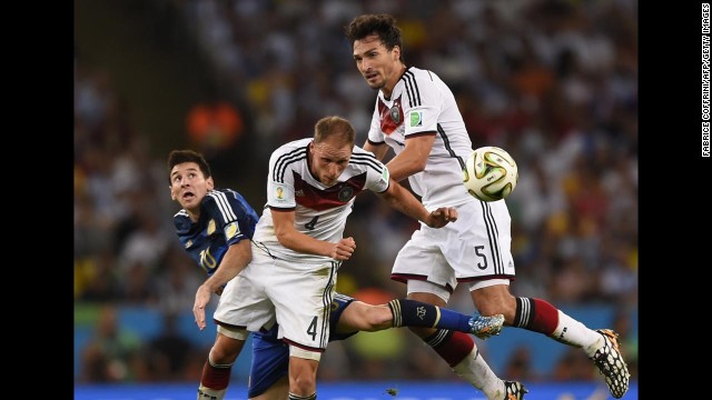 German defender Benedikt Howedes heads the ball away near Messi, left, and teammate Mats Hummels.