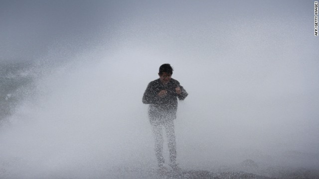 A resident stands near waves in Legazpi City, southeast of Manila, on July 15. Rammasun is expected to stay at typhoon strength until its final landfall in Vietnam.