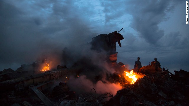 People walk amongst the debris at the site of a plane crash near the village of Grabovo, Ukraine, on Thursday, July 17. A Ukrainian official said a passenger plane carrying 295 people was shot down Thursday as it flew over the country, but both the government and the pro-Russia separatists fighting in the region denied any responsibility for downing the plane. 