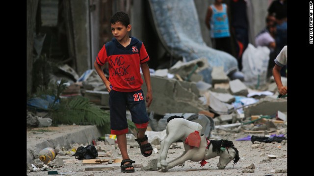 A Palestinian child walks on debris from a destroyed house following an overnight Israeli strike in Beit Lahiya on Saturday, July 19.