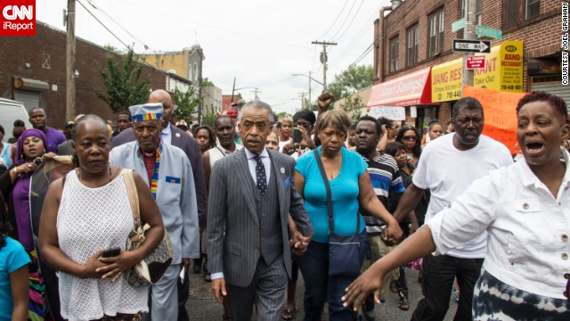 People participate in a demonstration against the death of Eric Garner after he was taken into police custody in Staten Island. Joel Graham photographed the demonstration, and captured this image of Garner's friends and family rallying alongside the Rev. Al Sharpton.