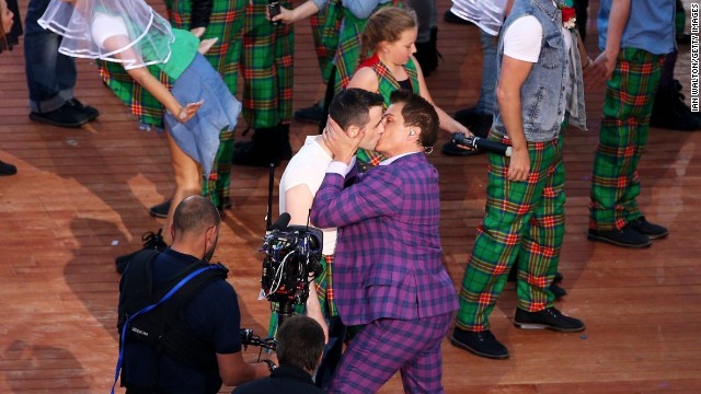 Actor and singer John Barrowman kisses another performer during the opening ceremony of the Glasgow 2014 Commonwealth Games on July 23, 2014.