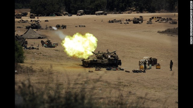 An Israeli tank fires toward Gaza from a position near Israel's border on July 24.
