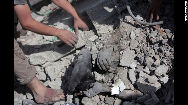 Palestinians dig a body out of the rubble of a destroyed house in Gaza during the cease-fire on July 26.