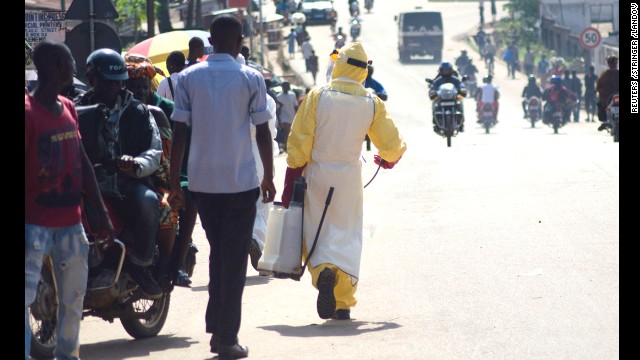 A health worker with disinfectant spray walks down a street outside the government hospital in Kenema, Sierra Leone, on Thursday, July 10. 