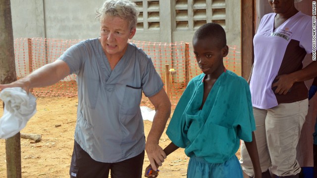 A 10-year-old boy whose mother was killed by the Ebola virus walks with a doctor from the aid organization Samaritan's Purse after being taken out of quarantine Thursday, July 24, in Monrovia.