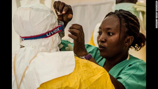 A dressing assistant prepares a Doctors Without Borders member before entering an isolation ward Thursday, July 17, in Kailahun.