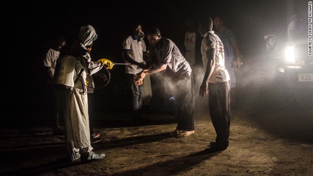 Red Cross volunteers disinfect each other with chlorine after removing the body of an Ebola victim from a house in Pendembu on July 18.