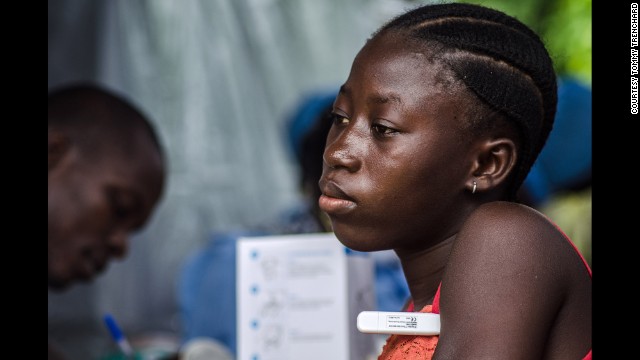 A woman has her temperature taken at a screening checkpoint on the road out of Kenema on Wednesday, July 9.