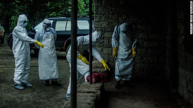 Red Cross volunteers prepare to enter a house where an Ebola victim died in Pendembu, Sierra Leone, on Friday, July 18.