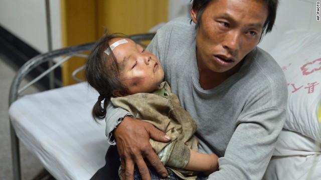 A man holds an injured child at a hospital in China's Ludian County on August 4.