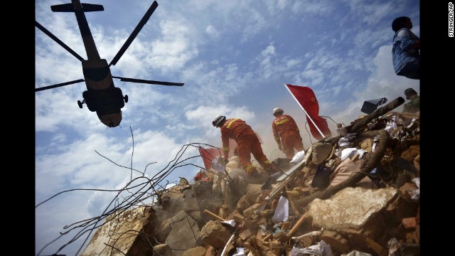 A helicopter flies over rescue workers Monday, August 4, in Longtoushan.
