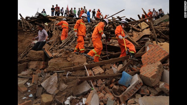 Rescue workers walk over rubble in Longtoushan on August 5.