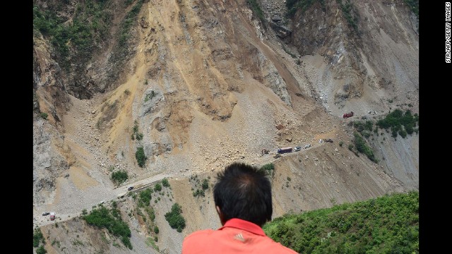 A man looks at a road buried by a landslide in Zhaotong, China, on Monday, August 4, a day after the earthquake.