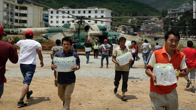 Volunteers deliver bottles of water brought by a helicopter to Longtoushan on August 6.