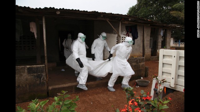 Nurses carry the body of an Ebola victim from a house outside Monrovia on Wednesday, August 6.