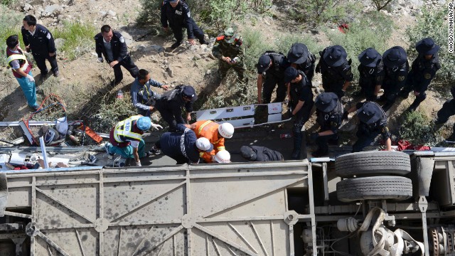 Rescuers work to pull victims from an overturned tour bus after it fell off a cliff in Nyemo County, Tibet, on Saturday, August 9. 