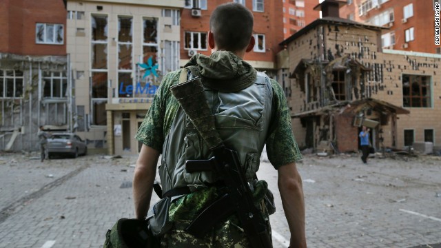 A pro-Russian rebel inspects damage after shelling in Donetsk on Thursday, August 7.