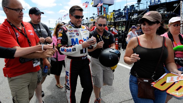 Stewart signs autographs for fans during a practice for the NASCAR Sprint Cup Series Camping World RV Sales 301 at New Hampshire Motor Speedway on July 11 in Loudon, New Hampshire.