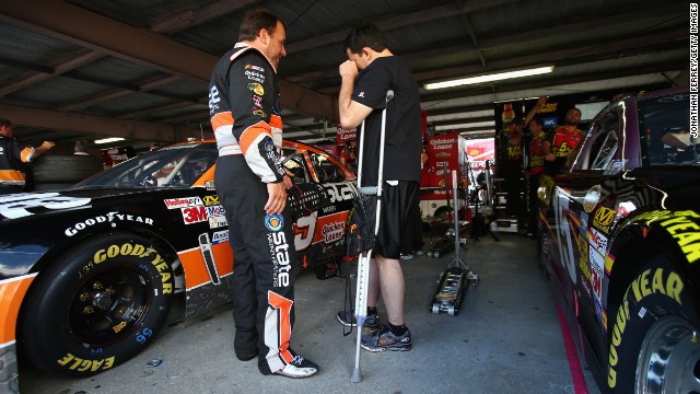 Driver Ryan Newman talks with team owner and injured driver Tony Stewart, on crutches, in the garage during practice for the NASCAR Sprint Cup Series AAA 400 at Dover International Speedway on September 28, 2013, in Dover, Delaware. Stewart broke his leg on August 5, 2013, during a race at the Southern Iowa Speedway in Oskaloosa, Iowa.